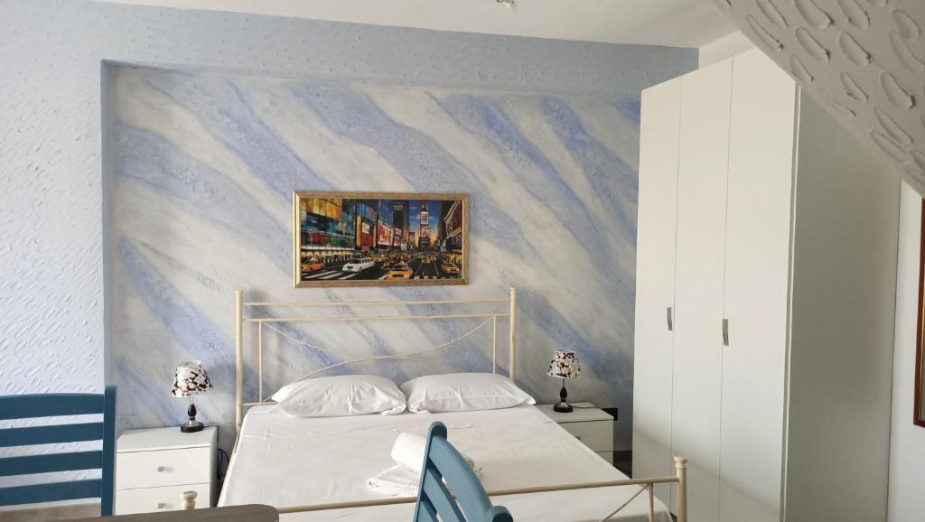 une chambre avec un lit avec un tableau sur le mur dans l'établissement RESINDENZE Donna Sabella, à Santa Flavia