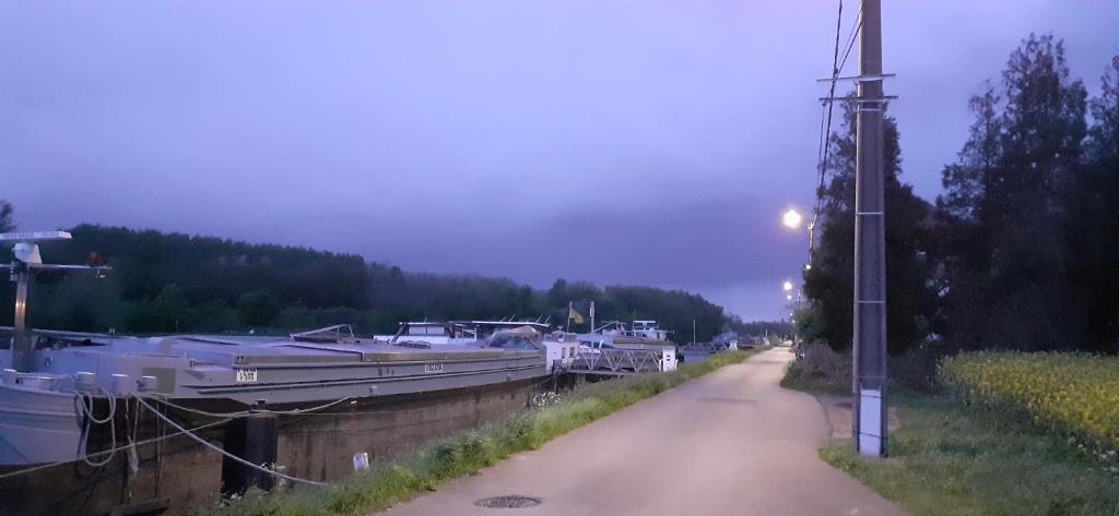 un canal avec des bateaux amarrés à côté d'une rue dans l'établissement Péniche à Béthune, à Béthune