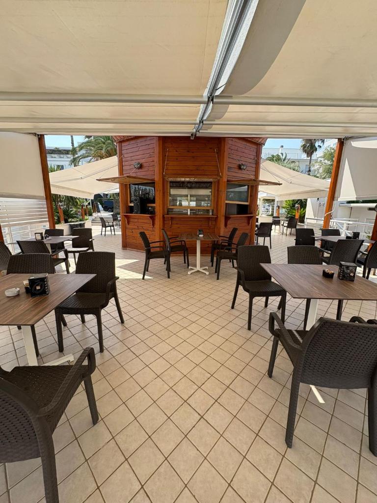 - un restaurant avec des tables et des chaises en bois dans l'établissement Hotel Haus Charlotte, à San Benedetto del Tronto