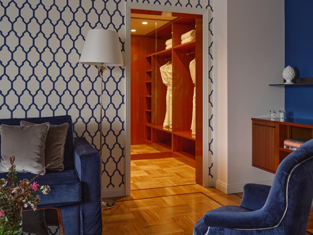 un salon avec un canapé bleu et des chaises dans l'établissement Grand Hotel Miramare, à Santa Margherita Ligure
