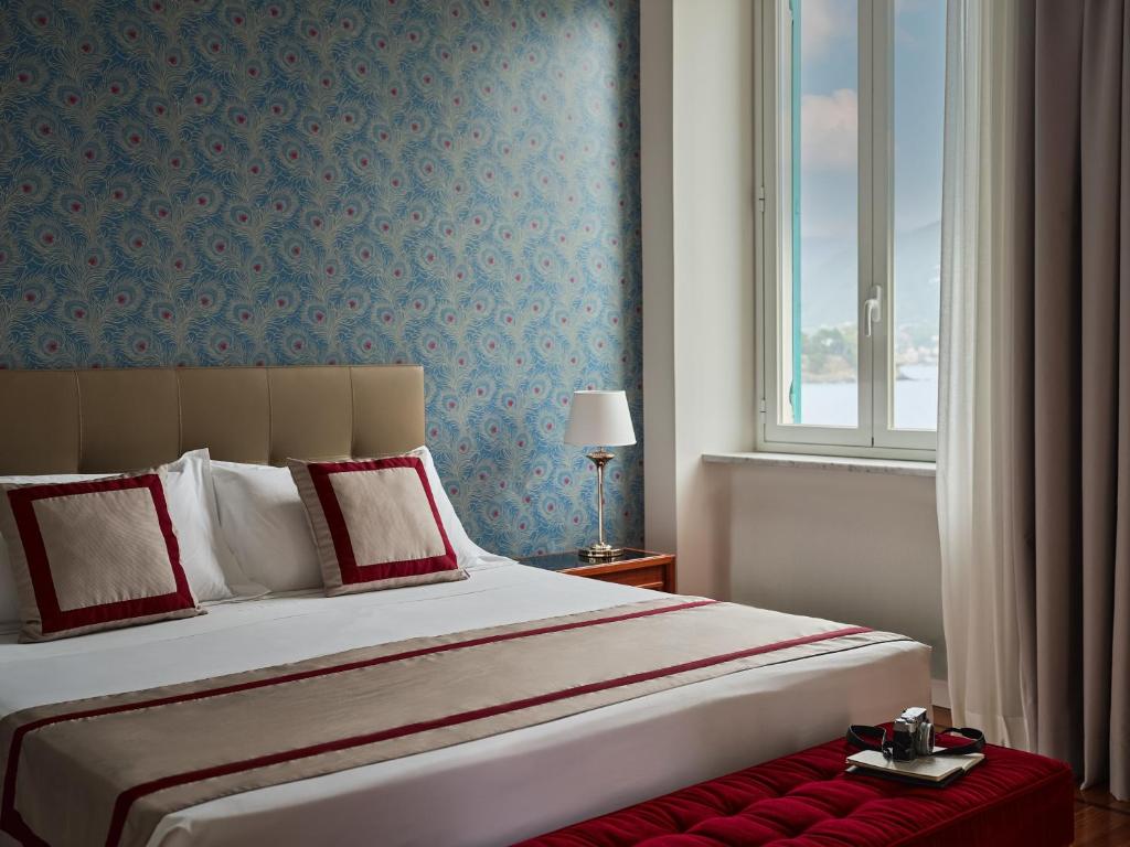 une chambre avec un grand lit et une fenêtre dans l'établissement Grand Hotel Miramare, à Santa Margherita Ligure