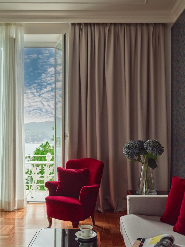 - un salon avec une chaise rouge et une fenêtre dans l'établissement Grand Hotel Miramare, à Santa Margherita Ligure