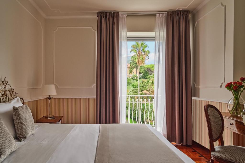 une chambre d'hôtel avec un lit et une grande fenêtre dans l'établissement Grand Hotel Miramare, à Santa Margherita Ligure