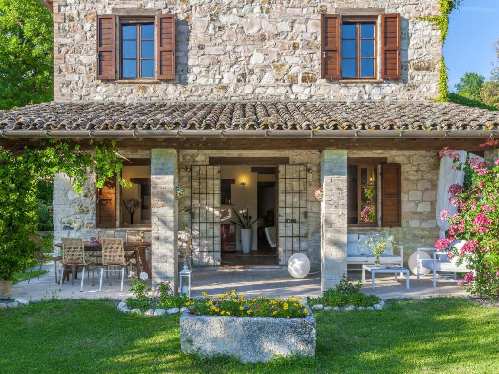 - une vue extérieure sur une maison en pierre avec un jardin dans l'établissement Marche Villa Close Culture, à Fermignano