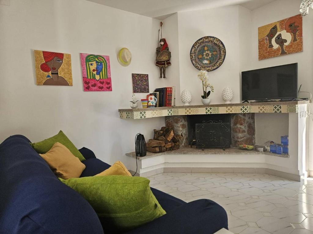 un salon avec un canapé bleu et une cheminée dans l'établissement Villa Rosa Holidays, à Altavilla Milicia