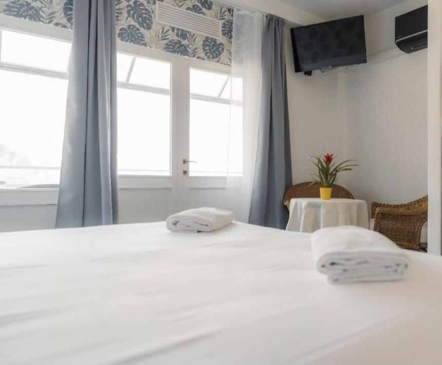 une chambre avec un grand lit blanc avec deux serviettes dans l'établissement Hotel Nautilus, à Valmadrera