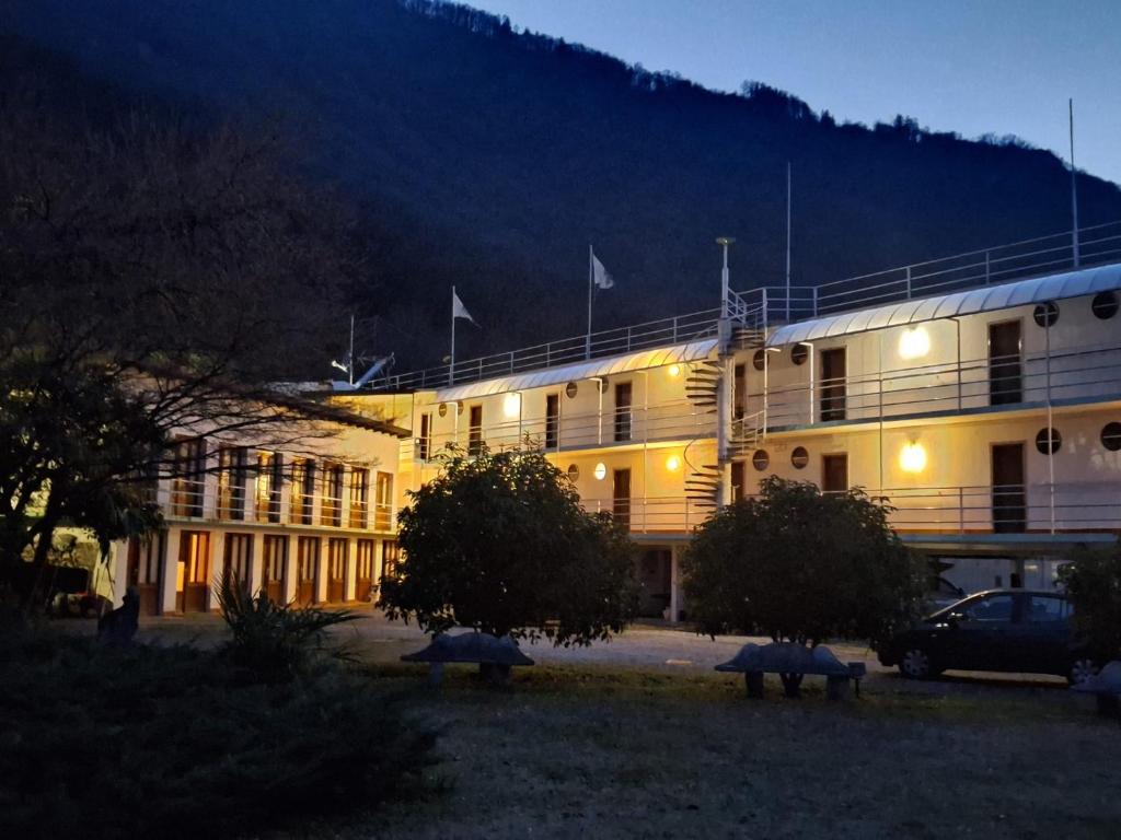 un grand bâtiment blanc avec une voiture garée devant. dans l'établissement Hotel Nautilus, à Valmadrera