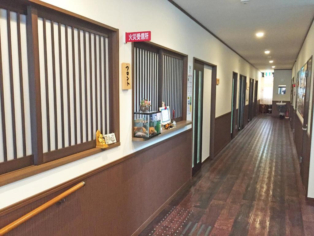 un couloir d'un hôpital avec des fenêtres et un long couloir dans l'établissement Onsenminshuku Kosakaya, à Nachikatsuura