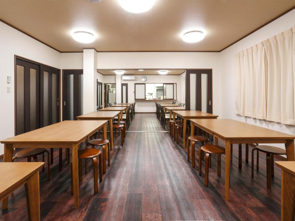 une rangée de tables et de chaises dans une pièce dans l'établissement Onsenminshuku Kosakaya, à Nachikatsuura