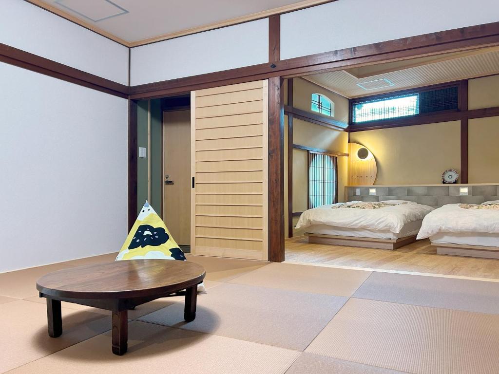- une chambre avec 2 lits et une table basse dans l'établissement Yamatoya, à Toyooka