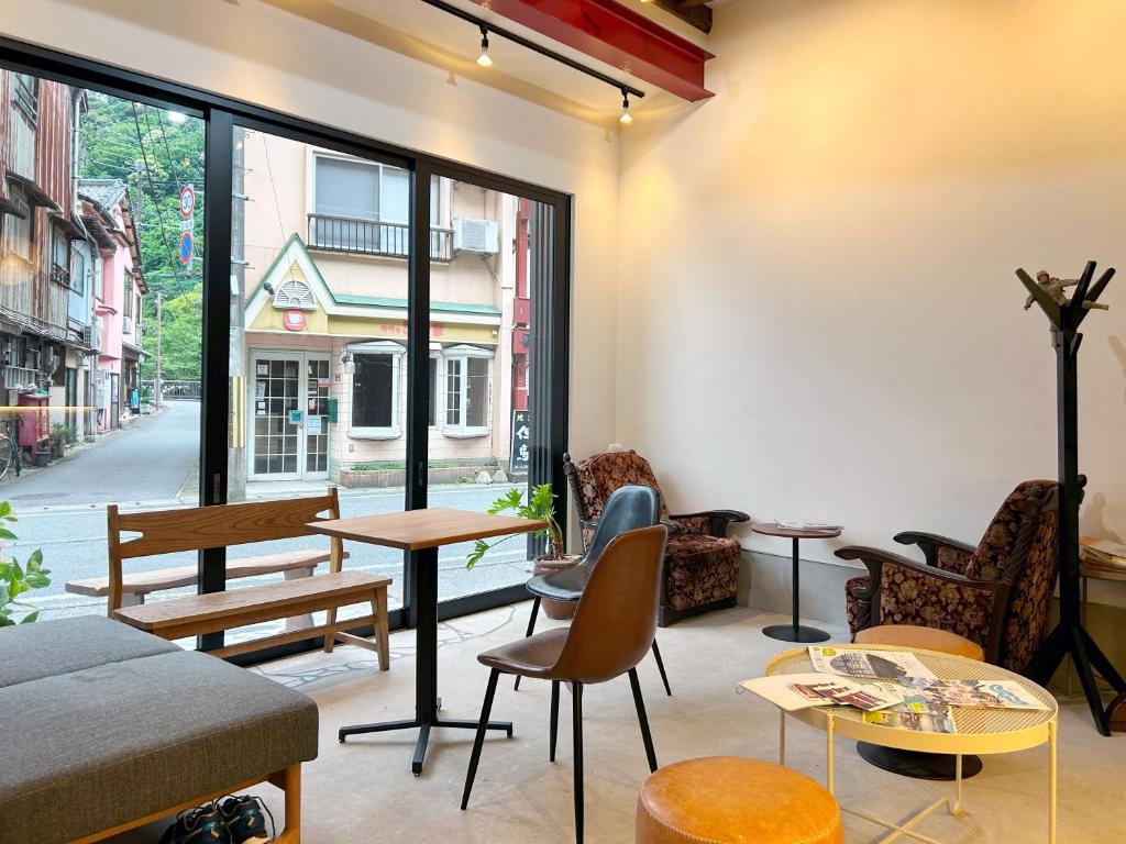 une chambre avec des tables, des chaises et une fenêtre dans l'établissement Yamatoya, à Toyooka