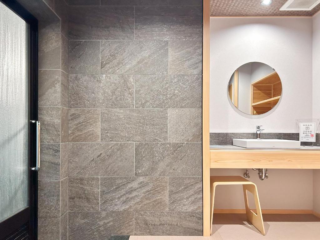 une salle de bain avec un lavabo et un miroir dans l'établissement Yamatoya, à Toyooka 37 autres photos