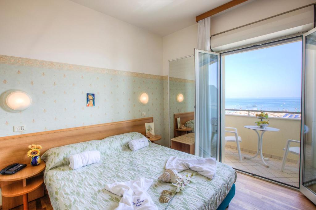 une chambre avec un lit et une vue sur l'océan dans l'établissement Hotel San Francisco Spiaggia, à Rimini