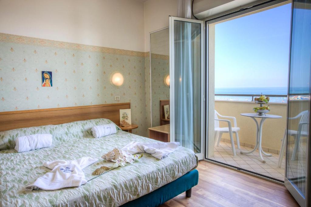 une chambre avec un lit et une porte coulissante en verre dans l'établissement Hotel San Francisco Spiaggia, à Rimini 160 autres photos