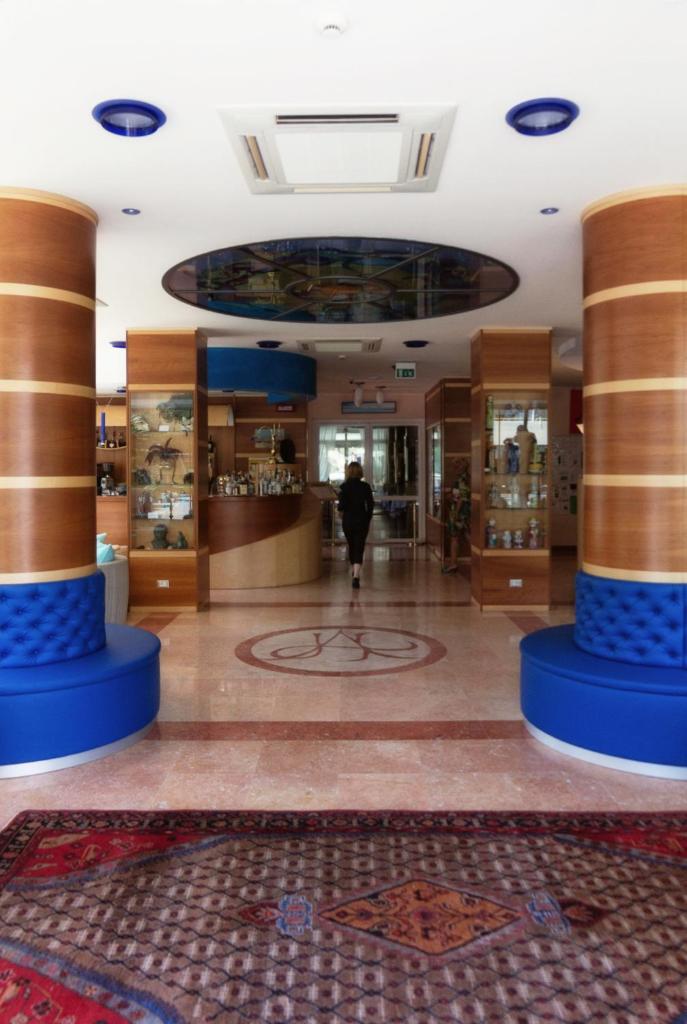une personne traversant un bâtiment avec colonnes dans l'établissement Hotel Arizona, à Lignano Sabbiadoro 118 autres photos