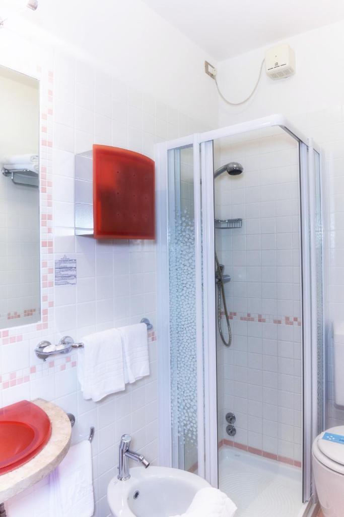 une salle de bain avec une douche, des toilettes et un lavabo dans l'établissement Hotel Arizona, à Lignano Sabbiadoro