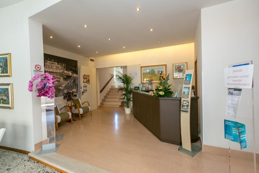 un hall d'entrée avec un bureau de réception dans un immeuble dans l'établissement Hotel Colonna, à Lido di Jesolo