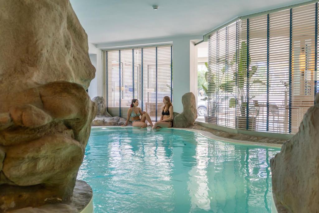 un groupe de trois femmes assises dans une piscine dans l'établissement Hotel Panorama, à Cattolica