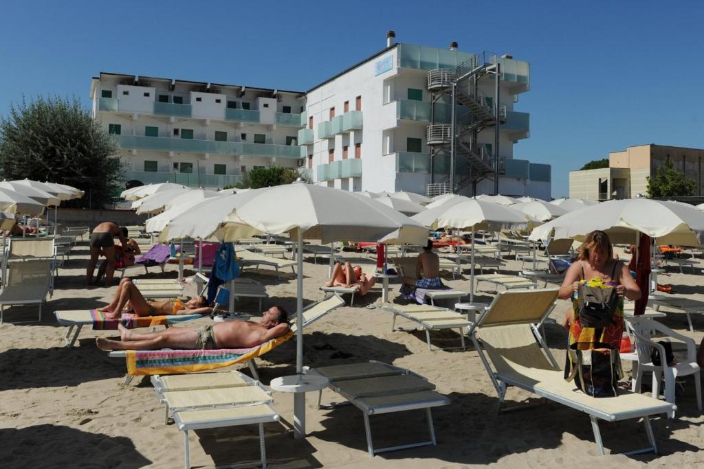 un groupe de personnes assises sur la plage sous des parasols dans l'établissement EuroHotel, à Cesenatico