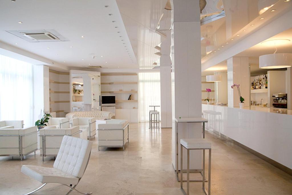 - un salon blanc avec des chaises blanches et un bar dans l'établissement Hotel Excelsior, à Vasto