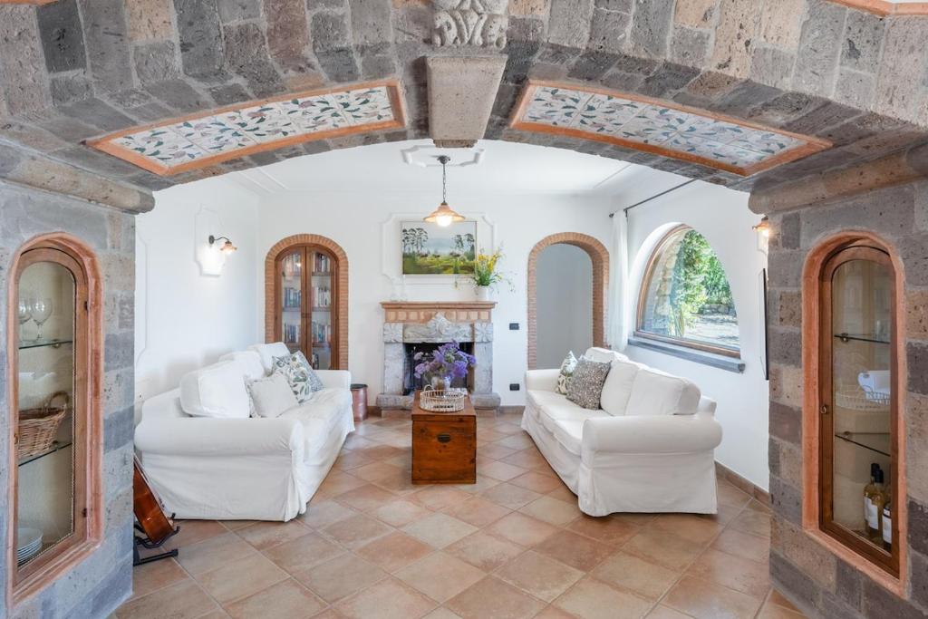 un salon avec deux canapés blancs et une cheminée dans l'établissement Villa Esposito, à Massa Lubrense