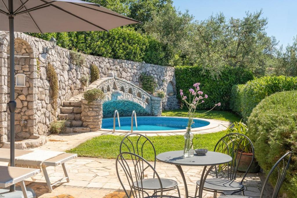 un patio avec une table et des chaises et une piscine dans l'établissement Villa Esposito, à Massa Lubrense