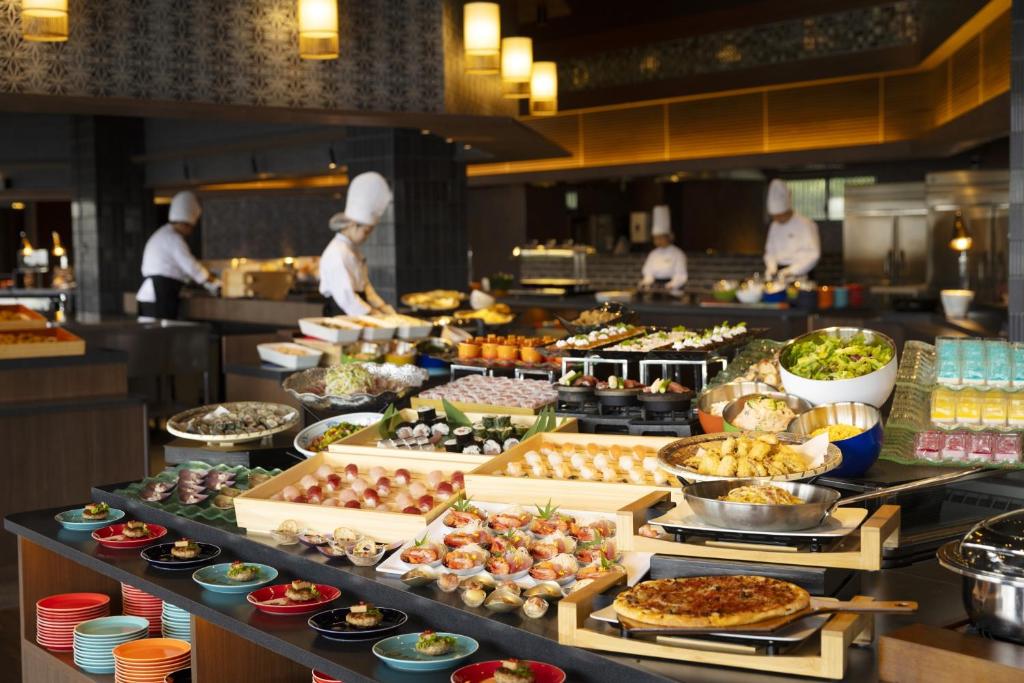 une ligne de buffet de nourriture dans un restaurant avec des chefs dans l'établissement TAOYA Nachikatsuura, à Nachikatsuura