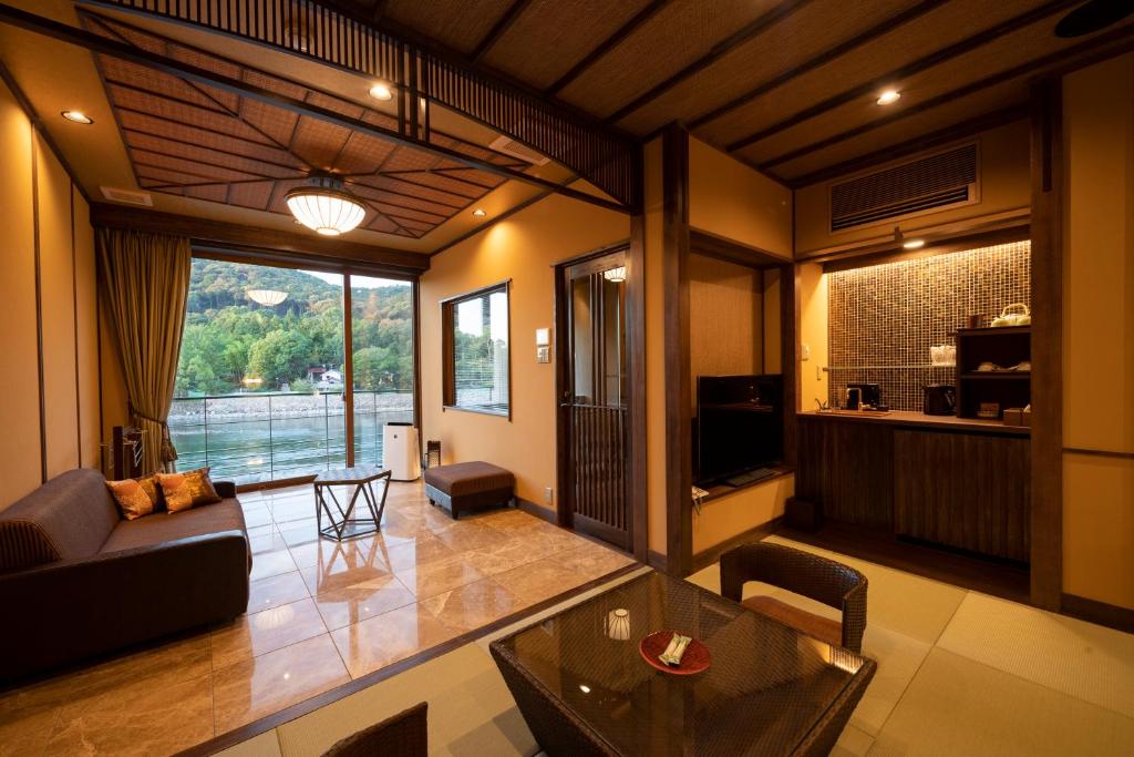 un salon avec un canapé et une table dans l'établissement Hanayashiki Ukifune-en, à Uji
