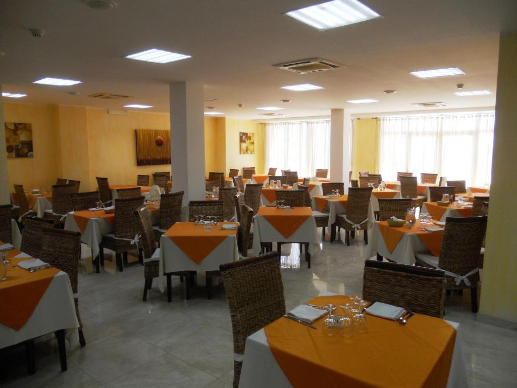une salle à manger avec des tables et des chaises dans une pièce dans l'établissement Hotel Club Ravezzo, à Lido Marini