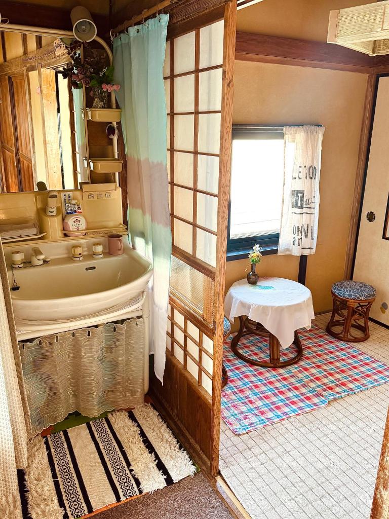 La salle de bains est pourvue d'une baignoire et d'une table. dans l'établissement Izu Hokkawa Seaside Guesthouse 伊豆北川の家, à Higashiizu