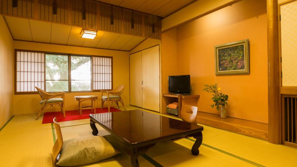 un salon avec une table basse et une télévision dans l'établissement Kotonoyado Musashino, à Nara