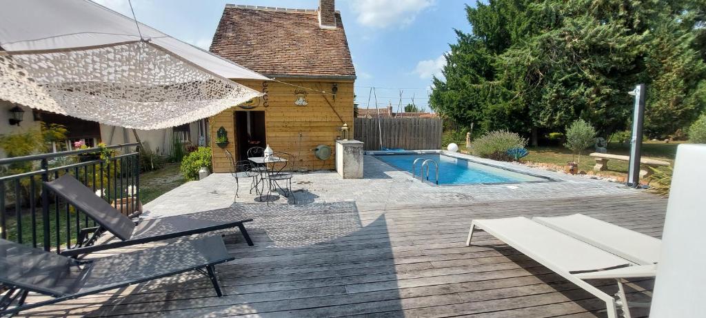 une terrasse en bois avec des chaises et une piscine dans l'établissement GITE HARY, à Villeblevin 23 autres photos