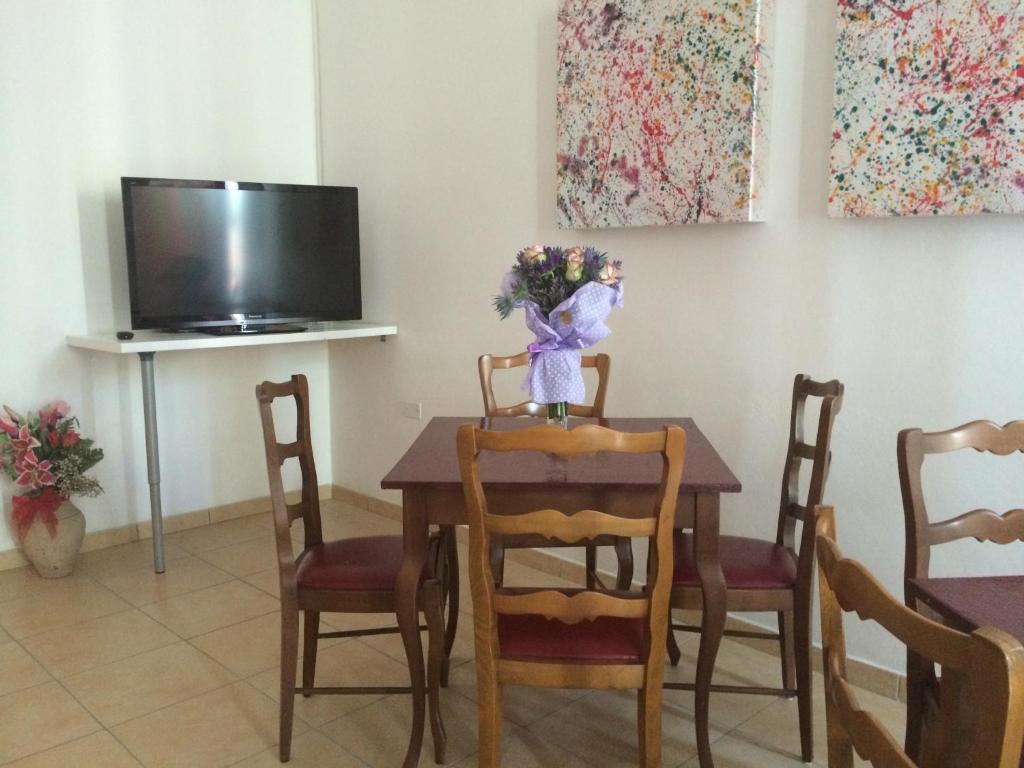une salle à manger avec une table et un vase de fleurs. dans l'établissement EuroHotel, à Cesenatico