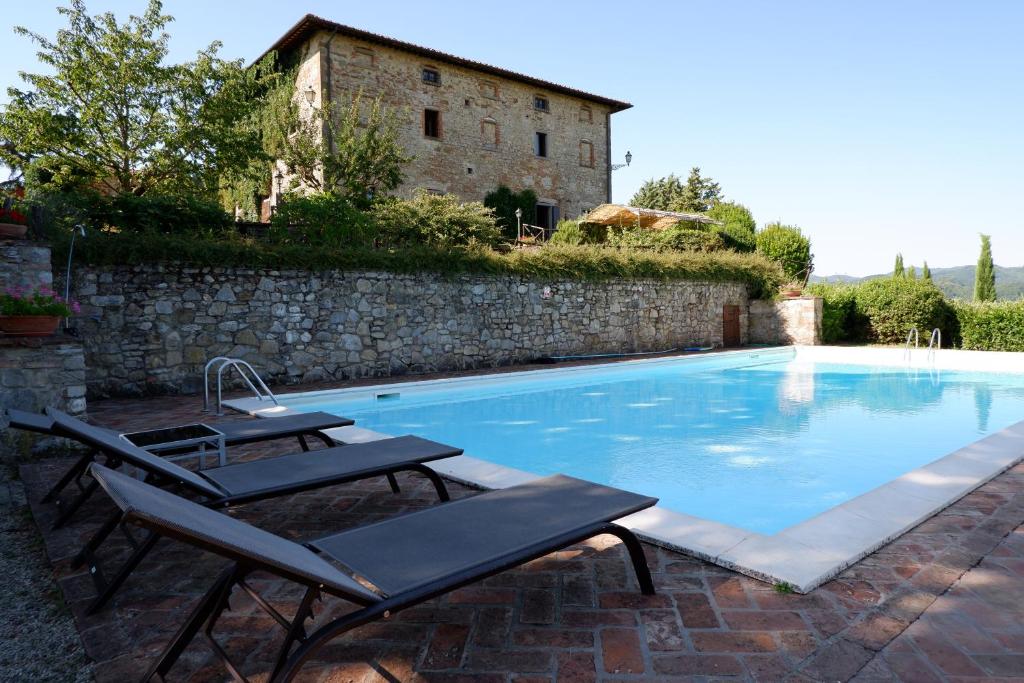 - une piscine avec 2 chaises longues à côté d'un bâtiment dans l'établissement Palazzo Prugnoli, Monte Santa Maria Tiberina, 8 Bedroom villa with private pool & superb views, à Pérouse