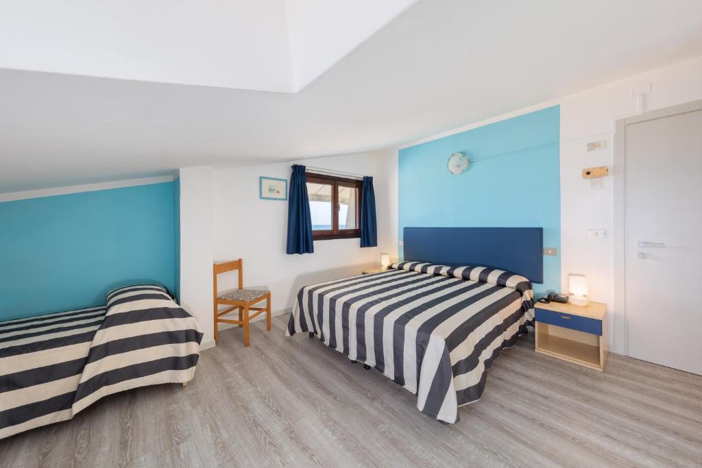 - 2 lits dans une chambre aux murs bleus et blancs dans l'établissement Hotel Gritti, à Lido di Jesolo