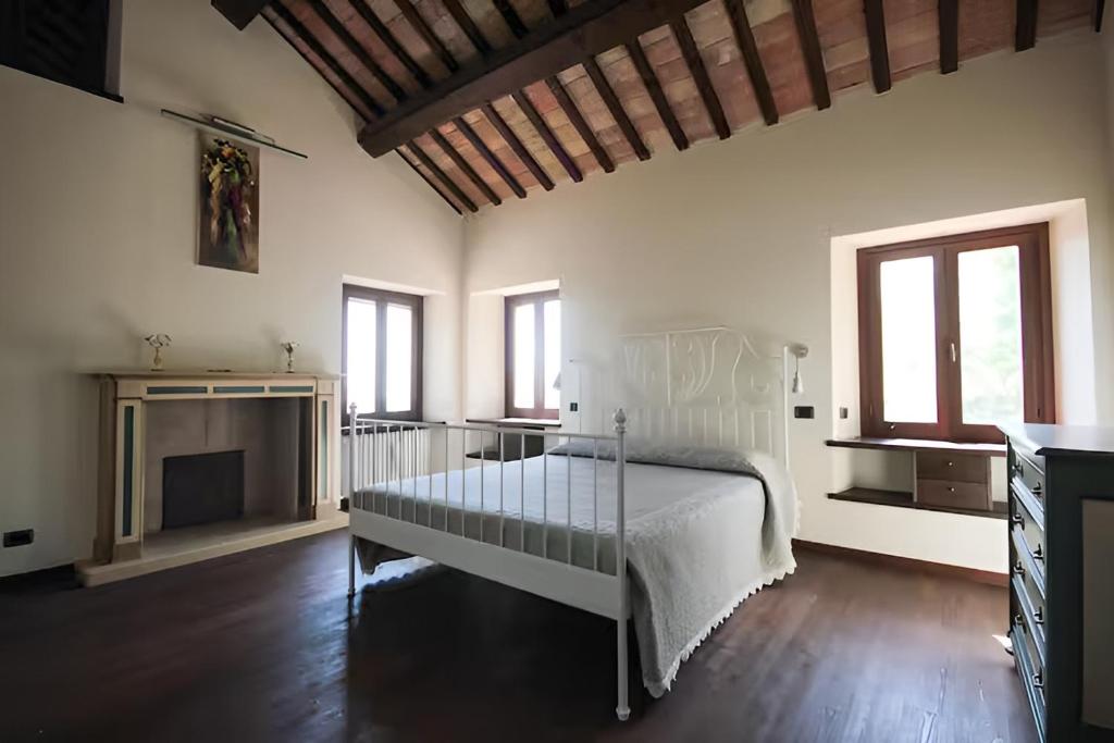 - une chambre avec un lit blanc et une cheminée dans l'établissement Villa Santa Maria, à Montegiorgio