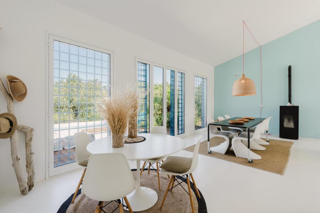 une salle à manger avec une table et des chaises blanches dans l'établissement casa zabbara, à Balestrate