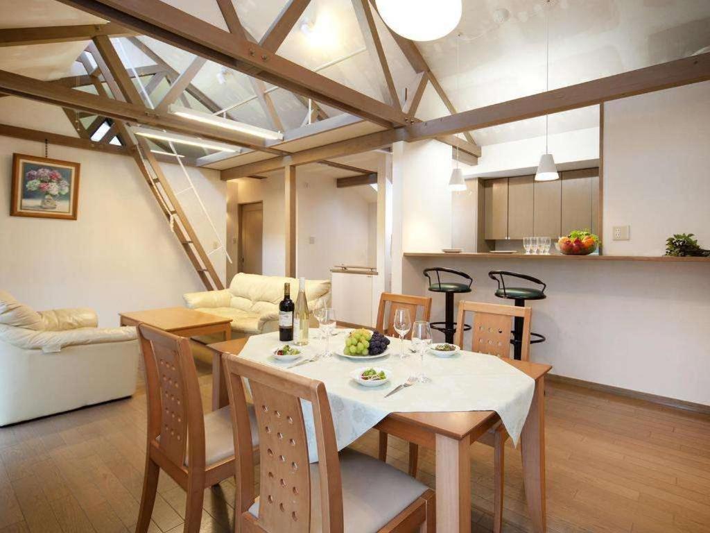 une salle à manger et une cuisine avec une table et des chaises dans l'établissement Izumigo Izukogen Dog Paradise Hotel & Cottage, à Itō