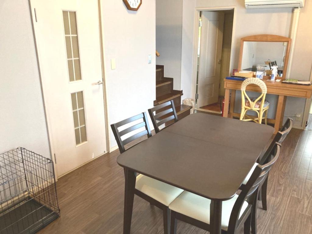 une salle à manger avec une table et des chaises noires dans l'établissement Izumigo Izukogen Dog Paradise Hotel & Cottage, à Itō