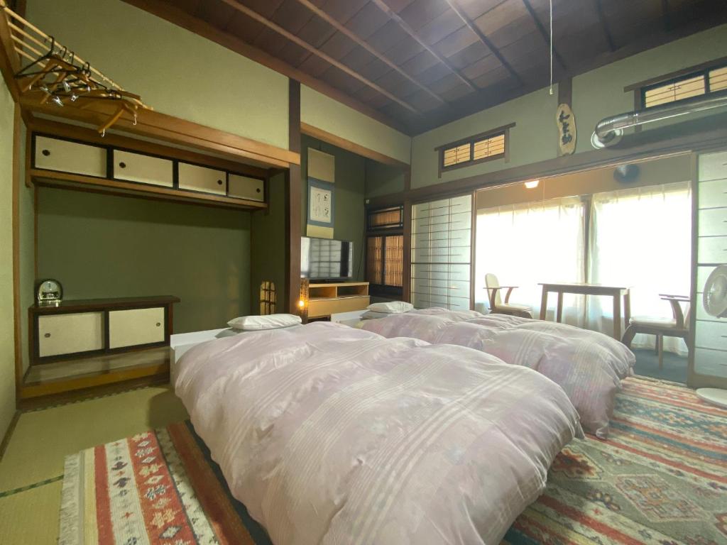 - une chambre avec 2 grands lits dans l'établissement Ryokan Sansui, à Furano