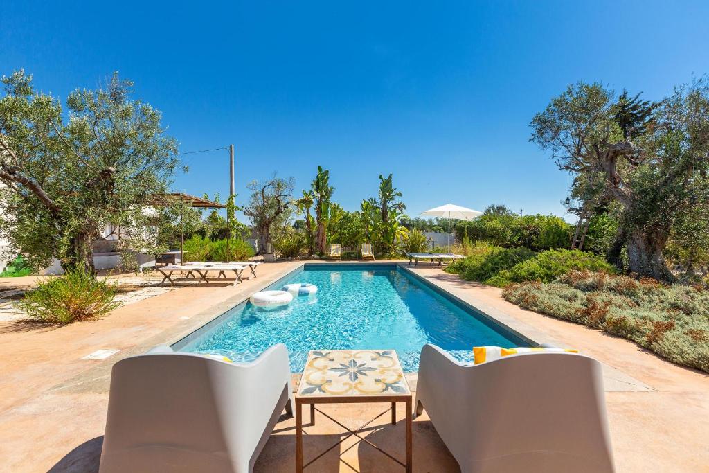 - une piscine avec 2 chaises et une table dans la cour dans l'établissement Le Cerase, à Salve