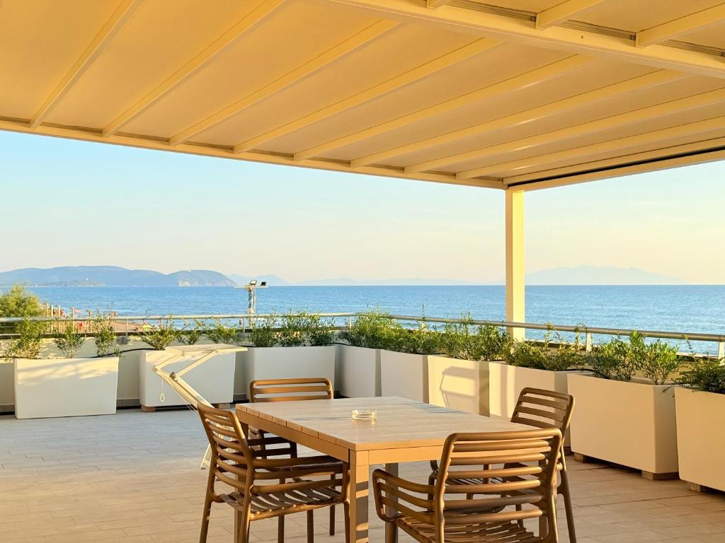 une table et des chaises sur une terrasse avec vue sur l'océan dans l'établissement Florida Apartments, à San Vincenzo