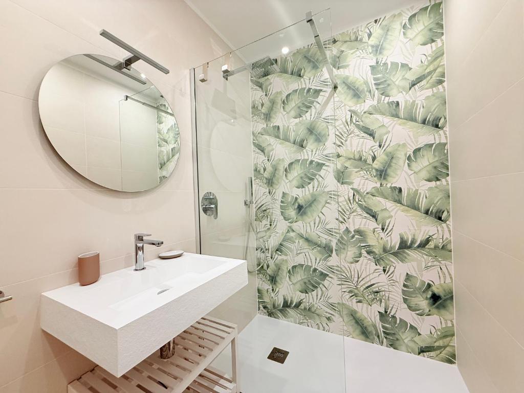 une salle de bain avec un lavabo blanc et un miroir dans l'établissement Florida Apartments, à San Vincenzo