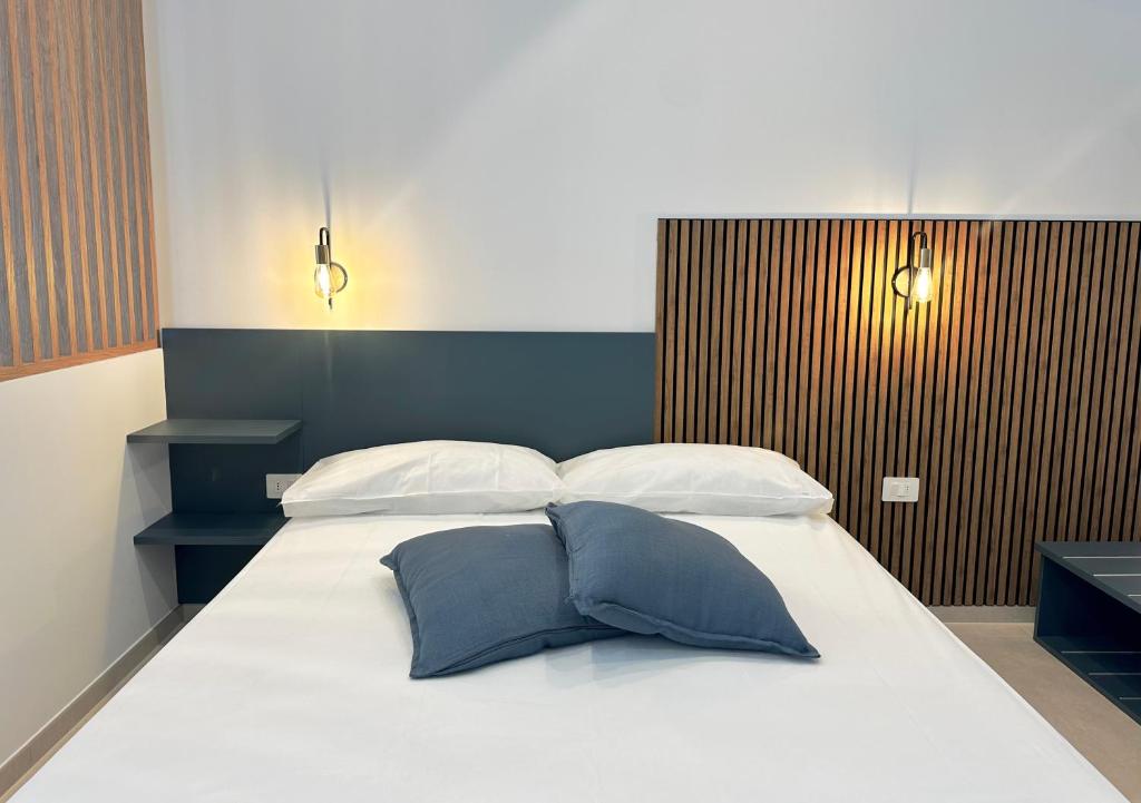 une chambre avec un grand lit avec deux oreillers dans l'établissement Florida Apartments, à San Vincenzo