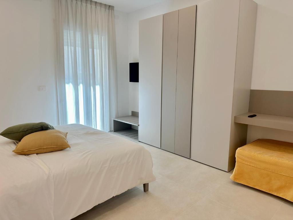 une chambre avec un lit blanc et une grande fenêtre dans l'établissement Florida Apartments, à San Vincenzo
