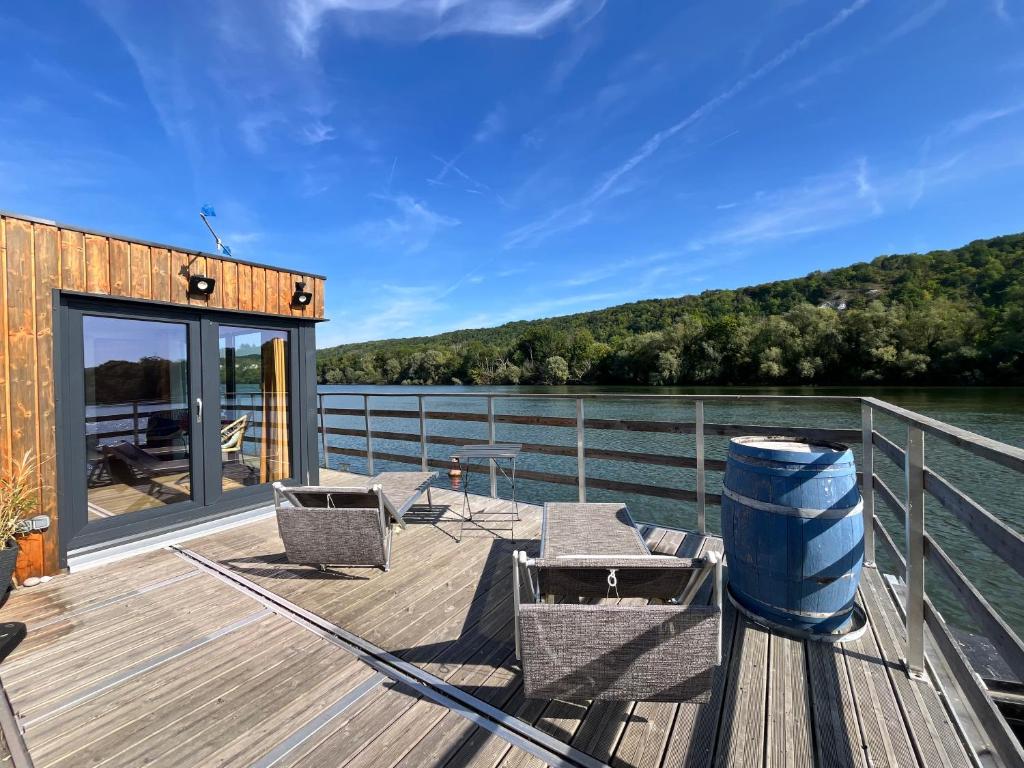une terrasse avec des chaises et des tables sur l'eau dans l'établissement Rêve Sur Eau - Terrasse - Bain De Soleil, à Moisson