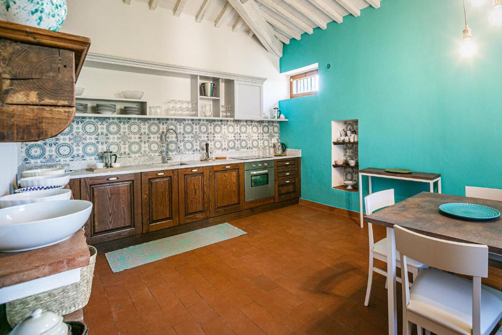 une grande cuisine avec des murs bleus et des placards en bois dans l'établissement Casa Oliveta, villa with private pool, à Aiola