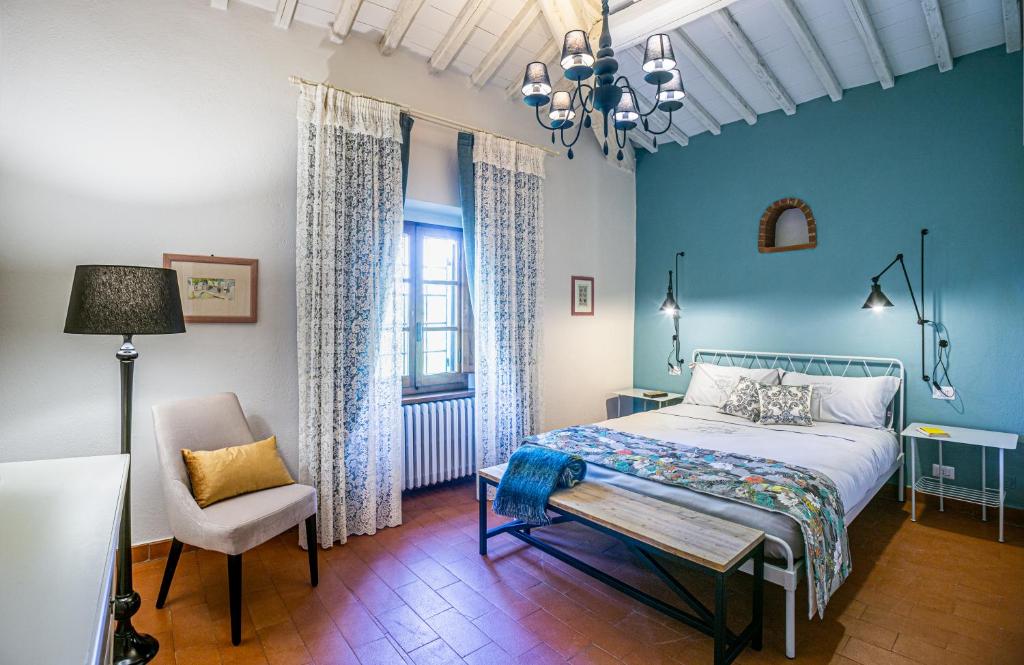 - une chambre avec des murs bleus, un lit et une chaise dans l'établissement Casa Oliveta, villa with private pool, à Aiola