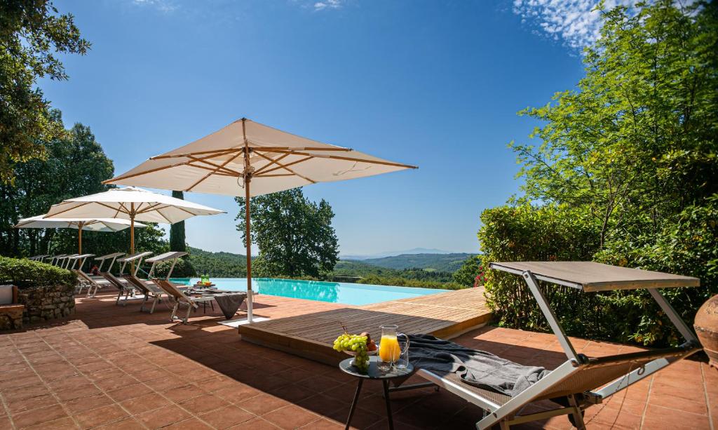 une terrasse avec des chaises et un parasol ainsi qu'une piscine dans l'établissement Casa Oliveta, villa with private pool, à Aiola 9 autres photos