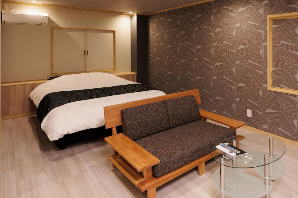 une chambre avec un lit, un canapé et une chaise dans l'établissement Hotel Room, à Miyazaki
